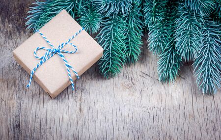 Christmas gift and fir branches. Gift box on wooden background copy spaceの写真素材