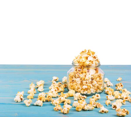 Delicious caramel popcorn on the table. Golden popcorn on white background. Homemade Popcorn in Jar.の写真素材