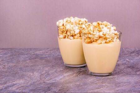 Homemade dessert in glasses. Homemade milk dessert. Vanilla Pudding with Popcornの写真素材
