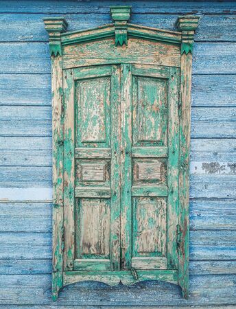 Old wooden window. Old window with closed wooden shutters. Shabby wooden shuttersの写真素材