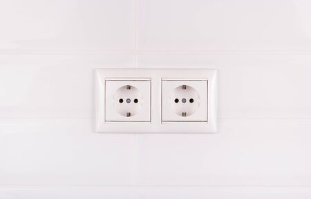 Double socket on white tile background. European electrical outletの写真素材