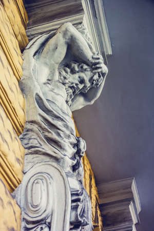 Statue of Atlant. Sculpture of a male body in the architecture of an ancient building.の写真素材