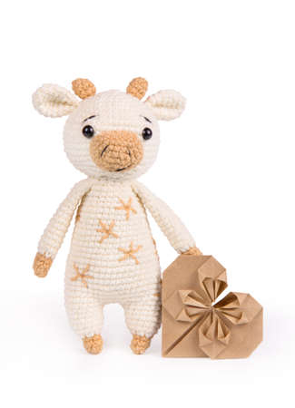 Knitted soft toy bull on white background and heartの写真素材