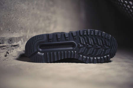 Black New Balance 574 sneakers shot outdoor on dark industrial background. Krasnoyarsk, Russia - January 9, 2018のeditorial素材