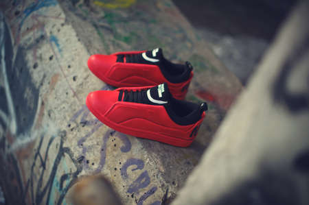 Beautiful red and black sneakers McQ By Alexander McQueen x Puma Brace Lo shot outdoor on colorful abstract background. Close up view of casual sport shoes. Krasnoyarsk, Russia - December 19, 2017のeditorial素材