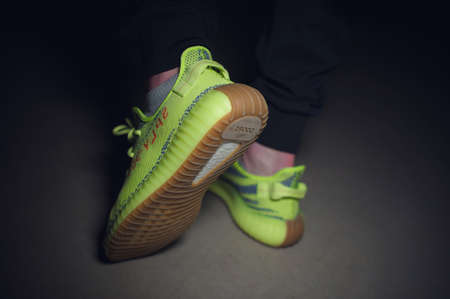 A man wearing Adidas Yeezy Boost 350 v2 Sply semi frozen yellow sport shoes. Krasnoyarsk, Russia - December 26, 2017のeditorial素材