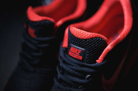 Perfect Nike Air Max 2017 sport shoes shot near the Mercedez Benz car on dark background. Sport and...