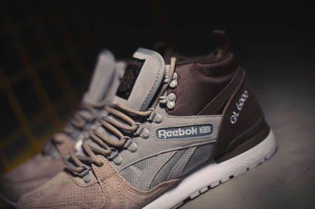 Reebok GL 6000 Mid sneakers in brown grey beige color shot outdoor on dark industrial background. Illustrative editorial close up photo of sport shoes shot in Krasnoyarsk, Russia - January 10, 2018のeditorial素材