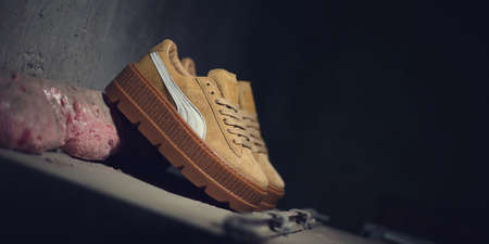 Beautiful Puma Suede Creepers by Rihanna on dark industrial background. Close up view of Fenty...