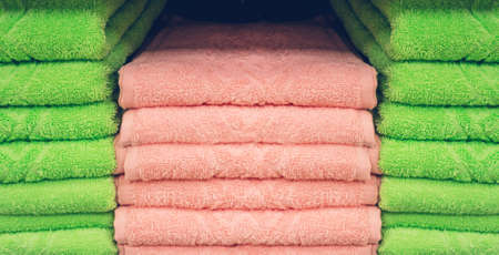 Stack of neatly folded cotton towels on a shelf. A pile of colorful towels on a store display.の写真素材