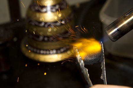 Flame burning a piece of charcoal and a shisha in the backgroundの写真素材