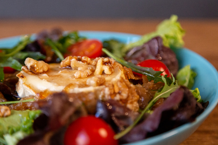 A close up of a salad with goat cheese, onion, peanuts, cherry tomatoes and vinaigretteの写真素材