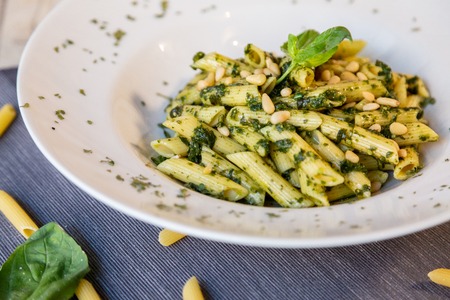 a macaroni basil pesto plate with parmesan cheese and pinionsの写真素材
