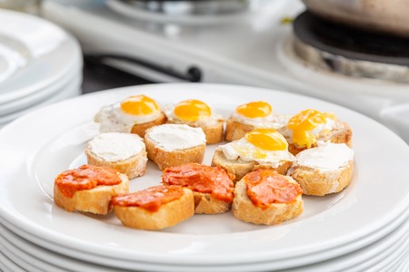 egg, cheese and sausage snacks on a white dishの写真素材