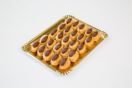 chocolate cupcakes in a gold tray on white backgroundの写真素材