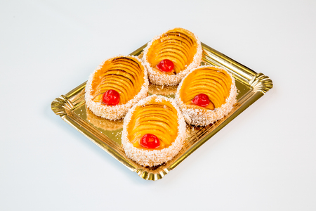 sweet pastries in a gold tray on white backgroundの写真素材