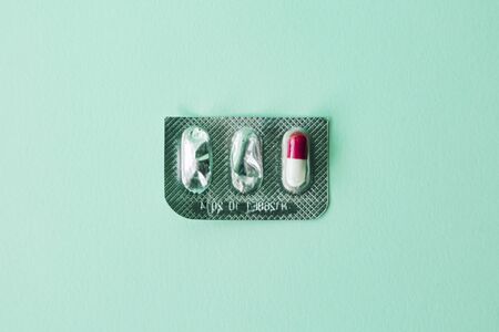 a isolated pill inside a empty blister on blue background. Concept of prescription and therapy.の写真素材