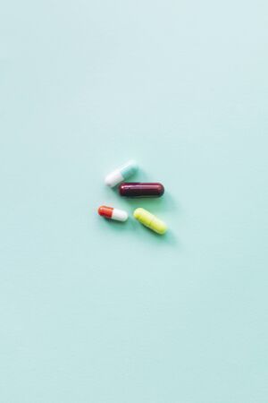 different colorful pills on a blue background with copy spaceの写真素材
