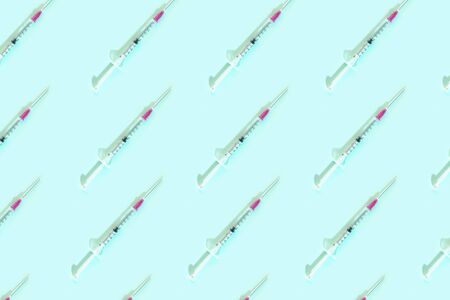 Pattern with syringes on blue background. Vaccine cure concept. Coronavirus illness.の写真素材