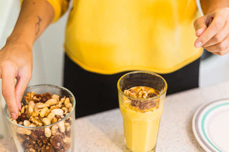 woman preparing a healthy smoothie with nuts