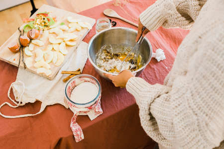 a womans hands mixing ingredients in a bowl and preparing a cakeの写真素材