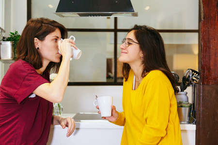 happy lesbian couple having breakfast in their kitchen