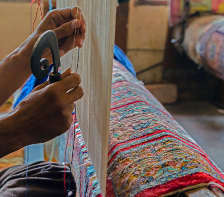 Hands working at one persian carpet inside in the manufacture from Srinagar, Jammu and Kashmir, India.の写真素材