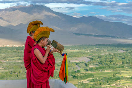 HEMIS, INDIA - AUGUST 12, 2017: Buddhist monks  blowing into a Tibetan specific instrument at the Hemis Monastery, a Tibetan Buddhist monastery (gompa).のeditorial素材