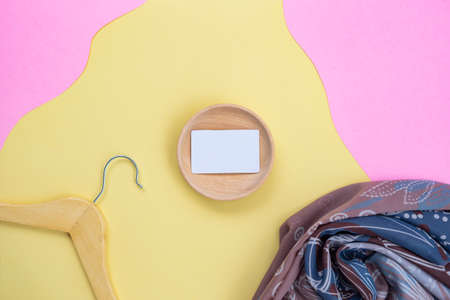 Business Card On Wood With Hanger And Scarf On A Yellow And Pink Background. minimalist styleの写真素材