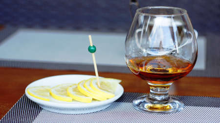 Brandy with lemon. A glass of brandy with slices of lemon, sprinkled with salt and pepper. This is the best remedy for a headache.の写真素材