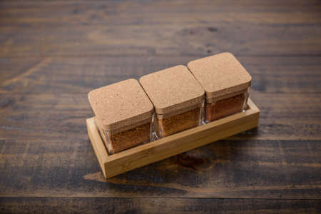 seasoning set on table with spoon and hand servingの写真素材