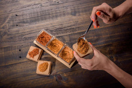 seasoning set on table with spoon and hand servingの写真素材