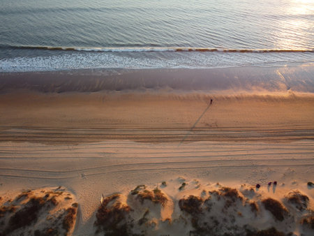 Flying over the shore of the Atlantic Ocean beach in Nuevo Portil, Huelva, Andalusia, Spain