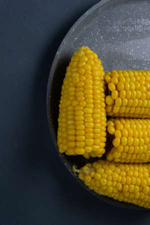 Fresh cooked yellow corn cobs lie on a gray dishの写真素材
