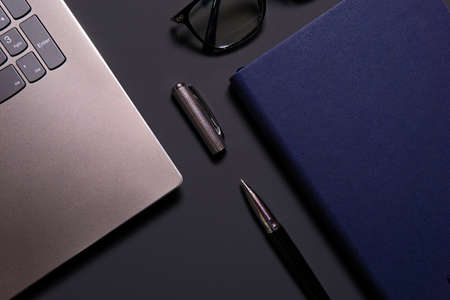 Notebook, laptop, glasses and pen on the table. Concept of business or study.の写真素材