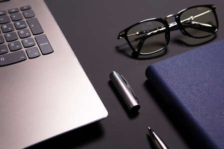 Notebook, laptop, glasses and pen on the table. Concept of business or study.の写真素材