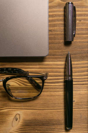 Notebook, laptop, glasses and pen on the table. Concept of business or study.