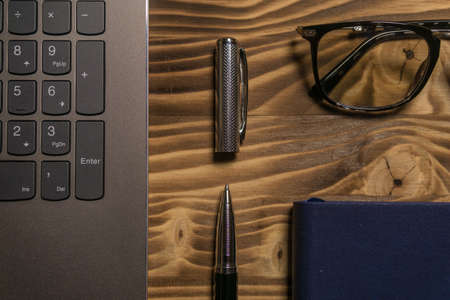 Notebook, laptop, glasses and pen on the table. Concept of business or study.の写真素材