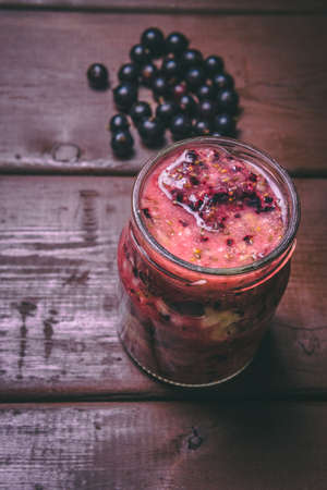 Fruit smoothies made with fresh ingredients on a wooden background. Black currant, orange and banana. Healthy food conceptの写真素材