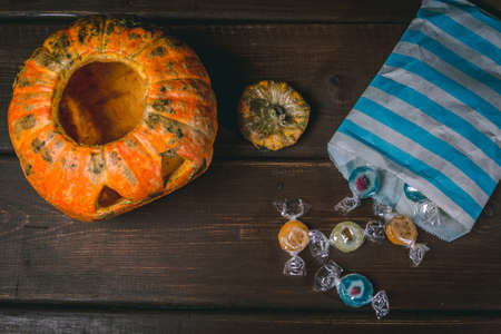 Happy Halloween pumpkin and candies. Trick or treat on a wooden table on a background of old wooden...