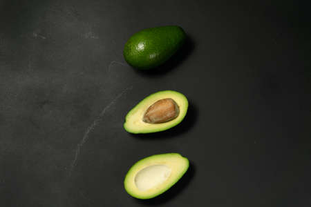 Fresh, raw avocado sliced on a black backgroundの写真素材