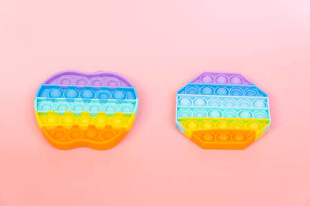 colorful silicone antistress sensory toy fidget push   on pink backgroundの写真素材
