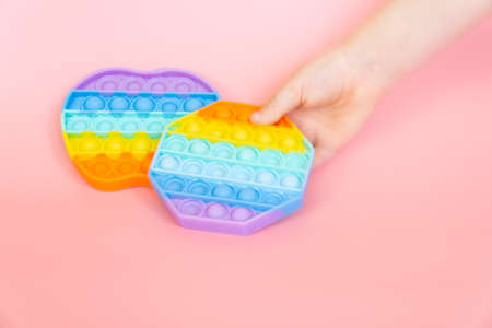 colorful silicone antistress sensory toy fidget push  on pink backgroundの写真素材