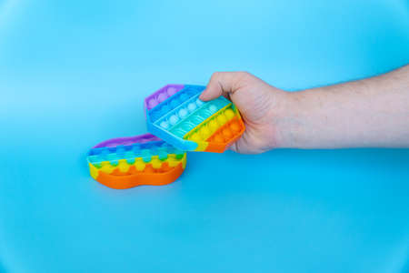 colorful silicone antistress sensory toy fidget push pop it on blue backgroundの写真素材