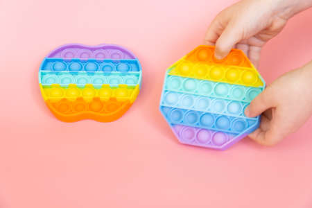 colorful silicone antistress sensory toy fidget push   on pink backgroundの写真素材