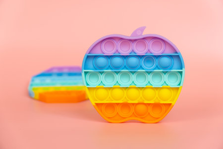 colorful silicone antistress sensory toy fidget push  on pink backgroundの写真素材
