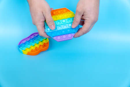 colorful silicone antistress sensory toy fidget push  on blue backgroundの写真素材