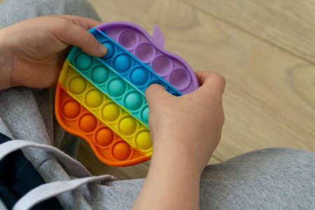 Silicone toy antistress . New trend. Colorful sensors toy in boy's handsの写真素材