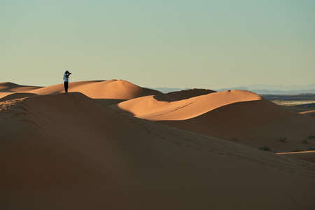 Merzouga, Morocco - December 05, 2018: a person in the middle of the desert, on top of a duneのeditorial素材
