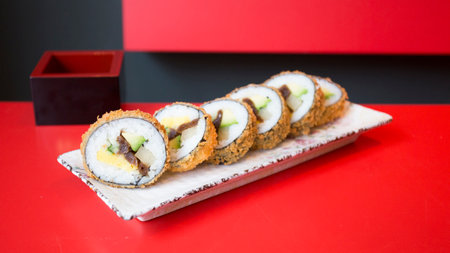 Fried vegan sushi roll with breadcrumbs. Rice roll stuffed with vegetables.の写真素材
